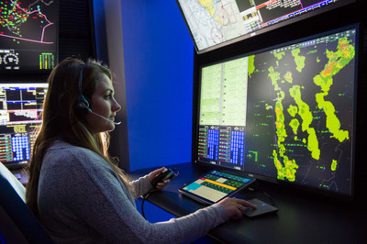 A woman utilizes advanced air traffic control technology.