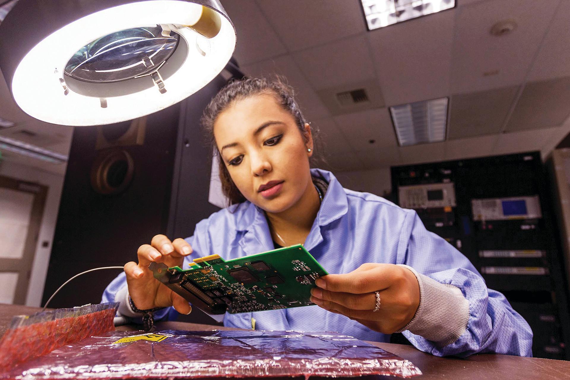 Woman looks at computer component