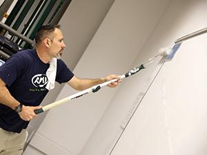 A volunteer painting a classroom wall.