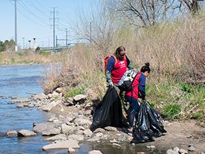 Volunteers picking up trash along the South Platte River.
