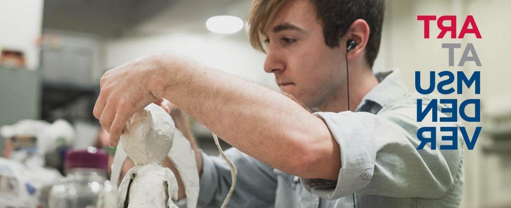 Student with headphones sculpting with clay