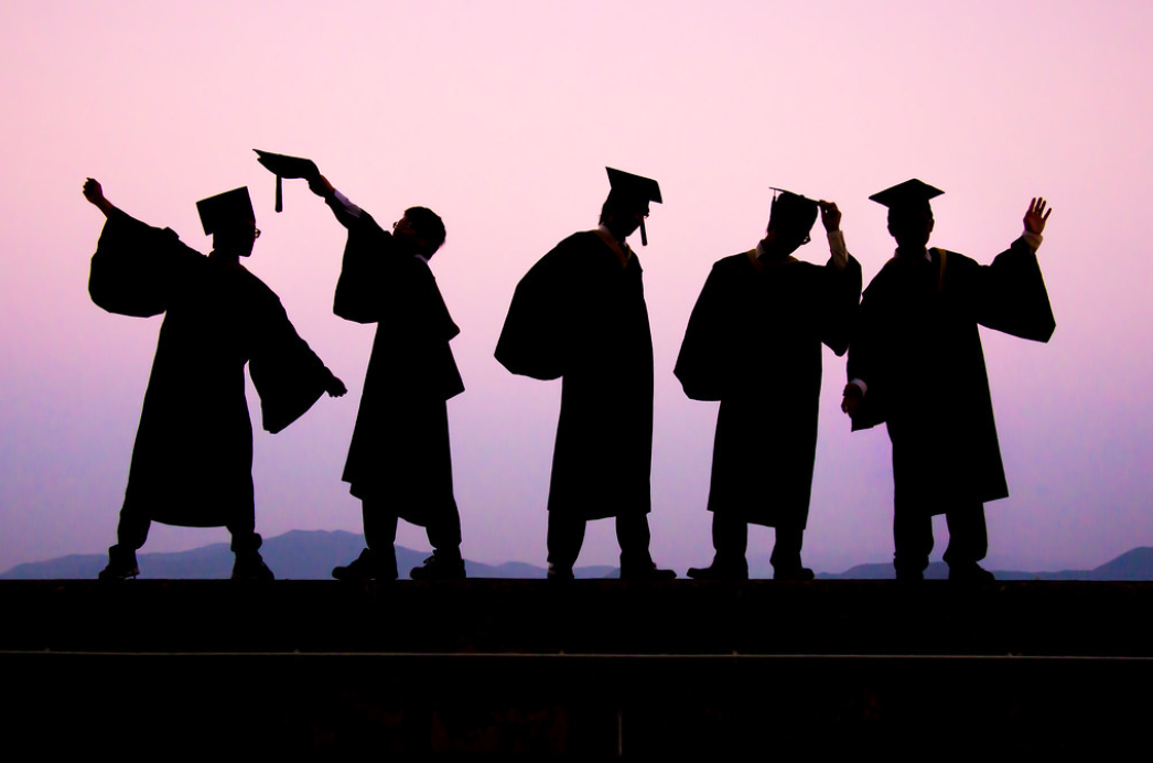 Five shadows of graduating students in commencement regalia
