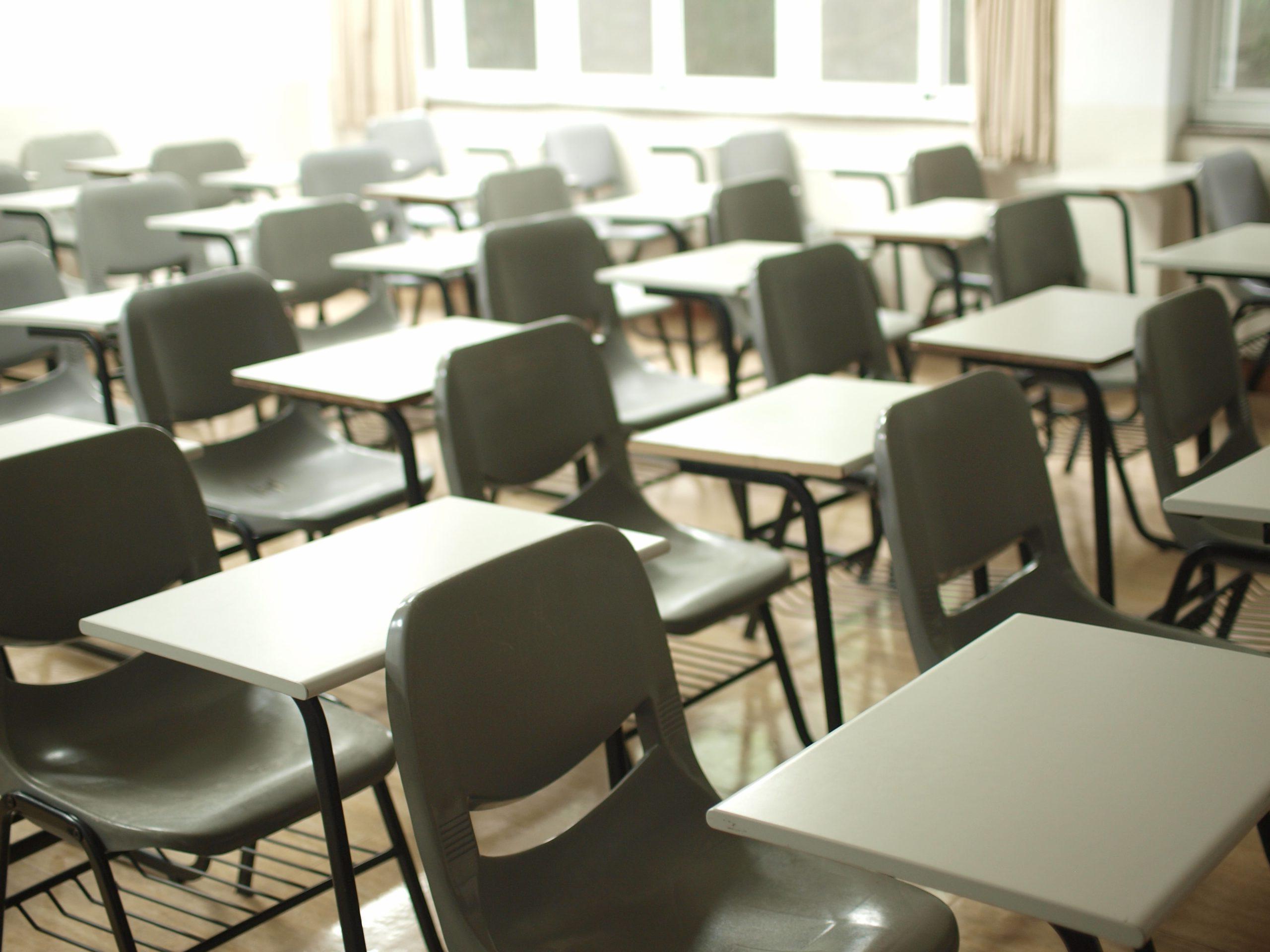 Rows of empty desks and chairs in a classroom