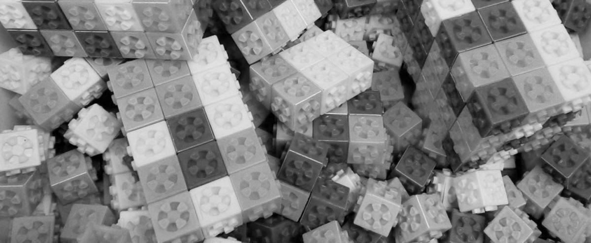 Black and white image of a pile of children's lego-style bricks.