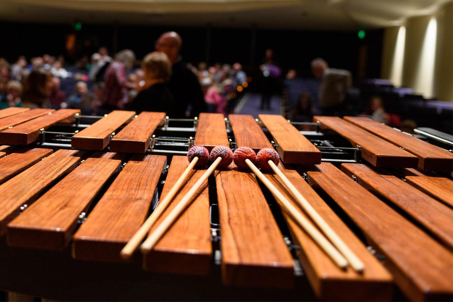 Marimba mallets resting on a marimba in a large concert hall