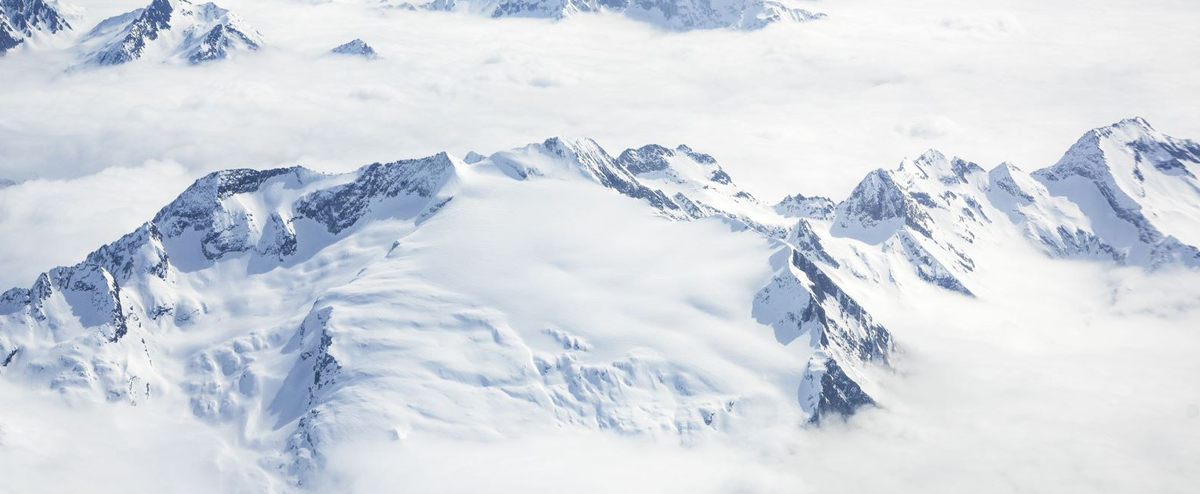Image of snowy mountain peaks above the clouds.