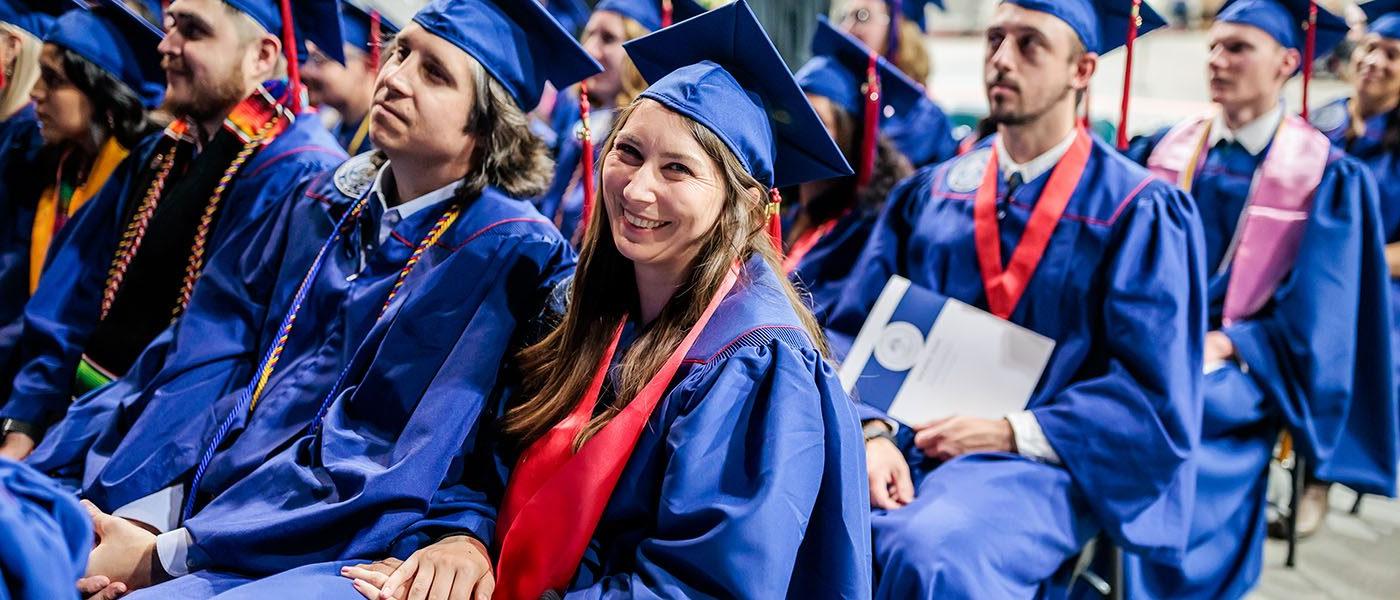 Happy graduates sit in the audience prepared to receive their diplomas at MSU Denver Spring 2023 commencement ceremony.